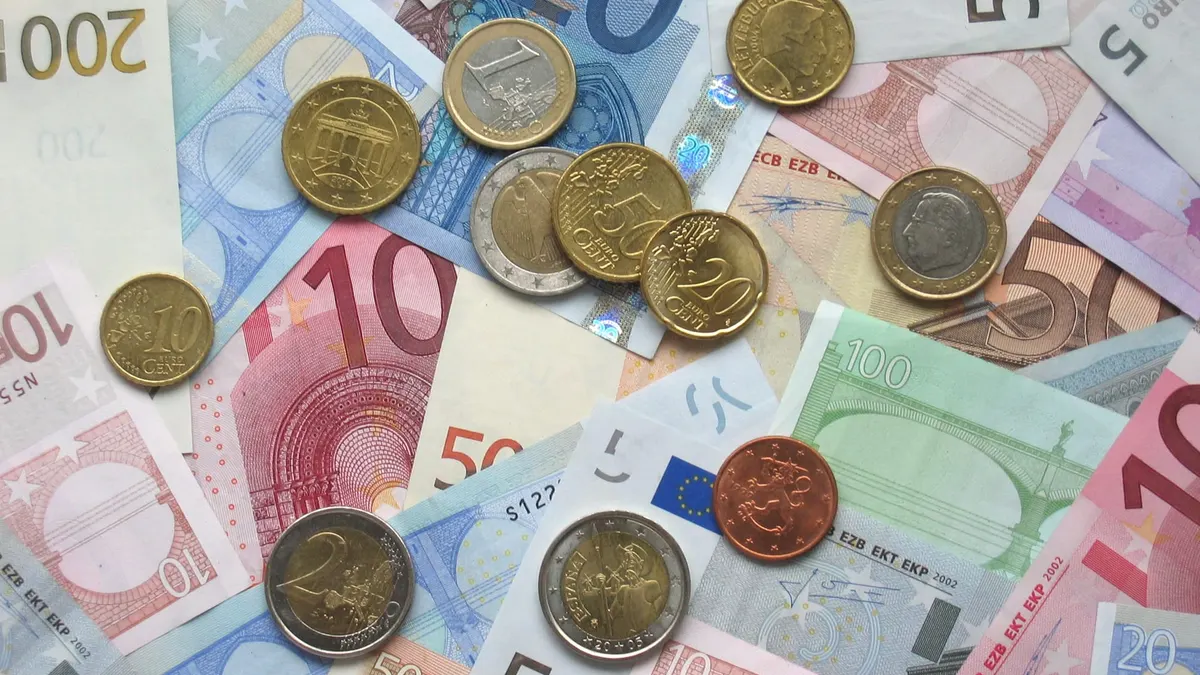 Monete e banconote in euro di vari tagli appoggiate su una superficie