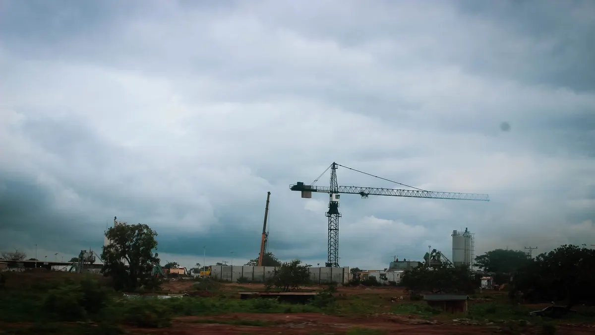 Gru da cantiere che si staglia contro il cielo sopra un'area di lavori