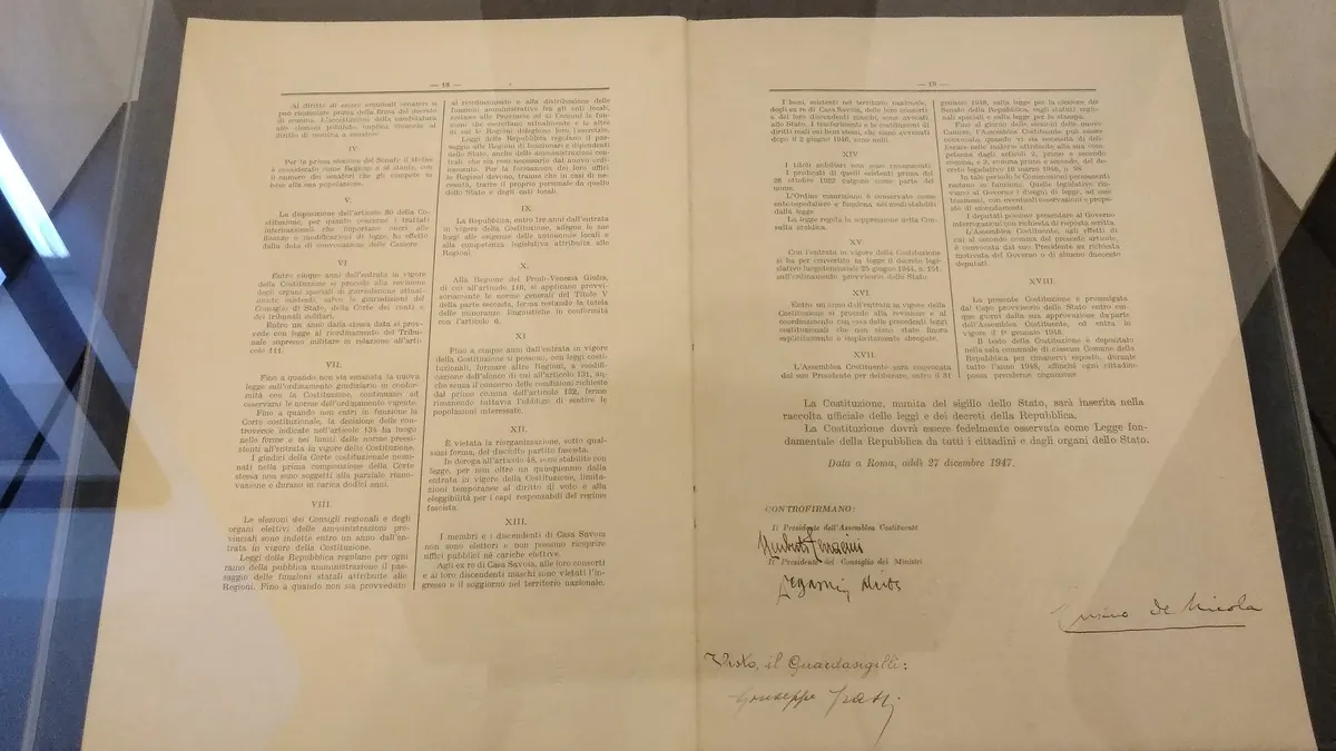 Pagine a stampa della Costituzione della Repubblica Italiana esposte sotto una teca di vetro