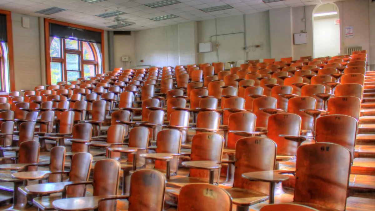 Aula con sedie e banchi disposti a gradinata, vuota
