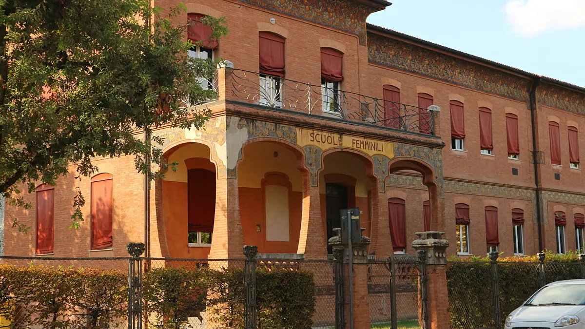 Edificio scolastico storico in mattoni con portico e decorazioni