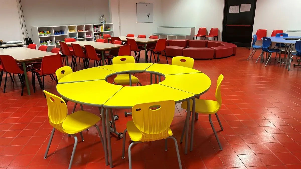 Ambiente di una scuola primaria con tavoli e sedie colorate