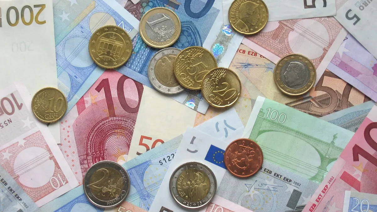 Monete e banconote in euro di vari tagli appoggiate su una superficie