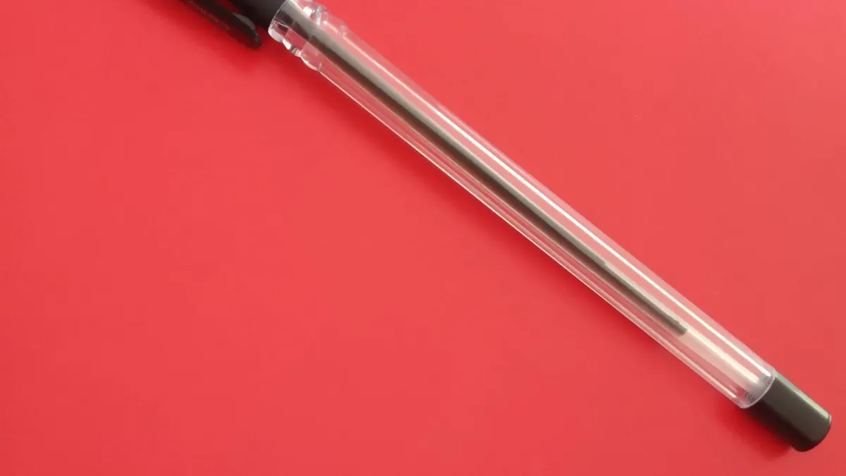 Una penna nera su sfondo rosso