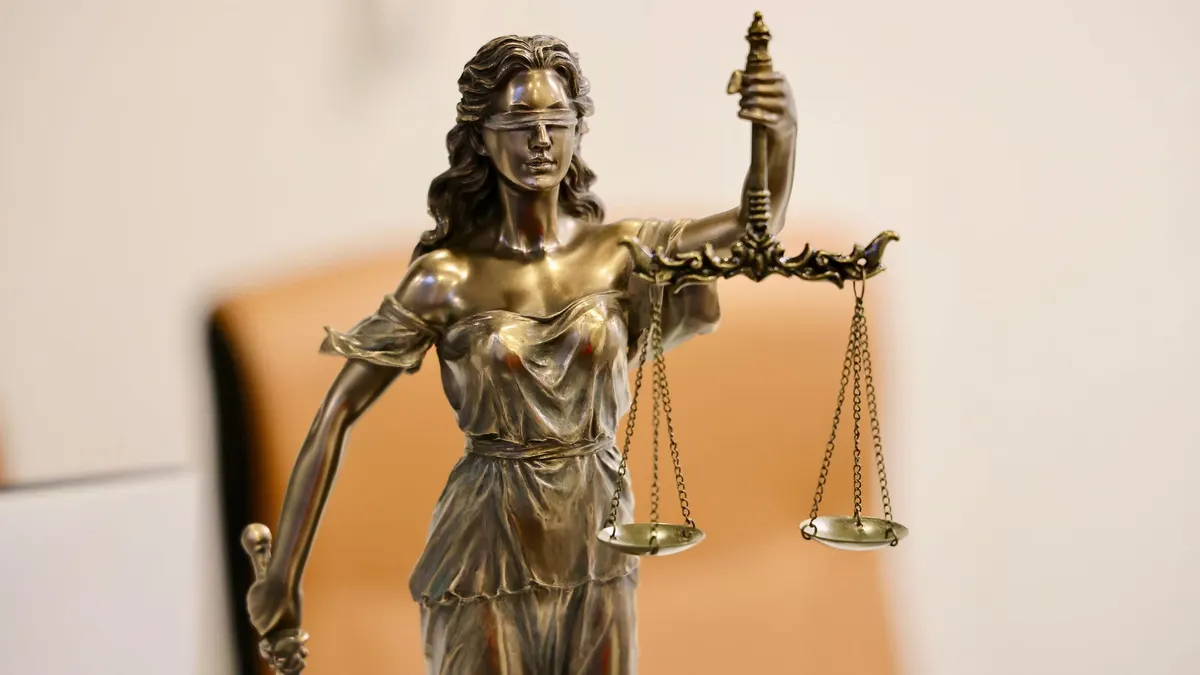 Primo piano della statua della Giustizia che regge la bilancia