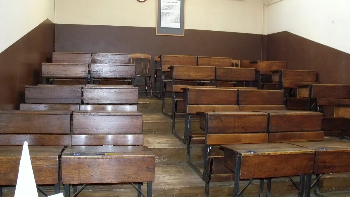 Aula storica con banchi di legno disposti a gradoni, senza persone